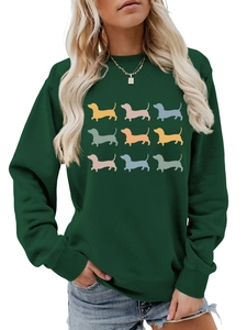 Close-up of ribbed cuffs and nine colorful dachshund silhouettes on a green sweatshirt
