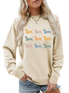 Close-up of nine colorful dachshund silhouette prints on beige crewneck sweatshirt