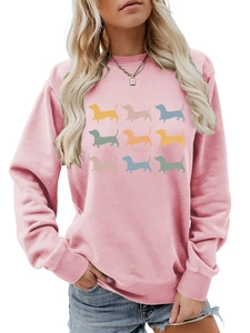 Detailed view of nine colorful dachshund silhouette prints on pink sweatshirt fabric