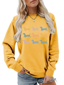 Close-up of ribbed crewneck and nine colorful dachshund silhouettes on yellow sweatshirt