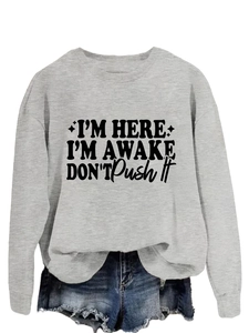 Detailed view of grey sweatshirt with I'm Here I'm Awake printed slogan and cotton texture