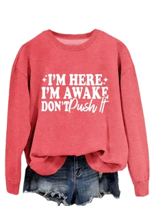 Detailed view of ribbed neckline and white slogan print on casual red crewneck sweatshirt