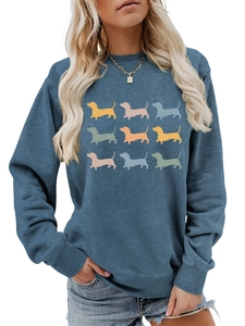 Detail of blue sweatshirt featuring nine colorful dachshund dog silhouettes in rows