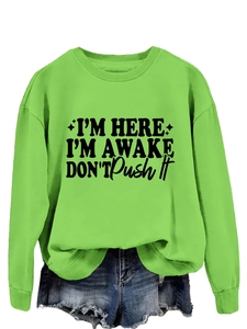 Close-up of text print on neon green sweatshirt with relaxed dropped shoulders