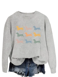Close-up of nine colorful dachshund silhouette prints on a grey crewneck sweatshirt