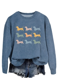 Detail of blue crewneck sweatshirt featuring nine colorful dachshund silhouette prints
