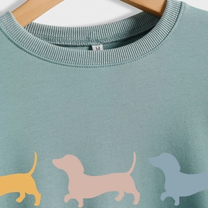 Light green crewneck sweatshirt with cute colorful dachshund silhouettes in size M