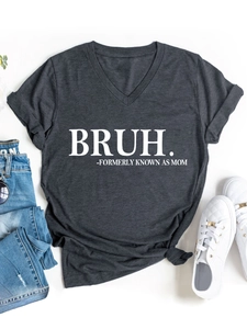 Flat lay of charcoal V-neck T-shirt with white text print beside denim jeans and sneakers