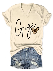 Détail du t-shirt col en V avec texte Gigi et motif cœur léopard sur tissu beige