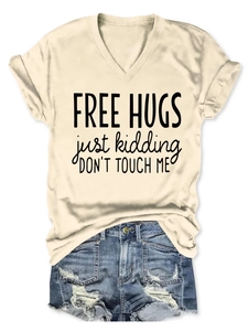 Detail of V-neck beige t-shirt with Free Hugs print and distressed denim shorts