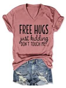 Flat lay of pink V-neck T-shirt with Free Hugs print and distressed denim shorts
