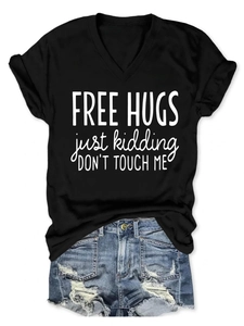 Flat lay of black V-neck T-shirt with Free Hugs print and distressed denim shorts