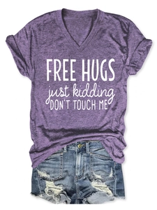 Purple V-neck T-shirt with 'FREE HUGS' slogan paired with frayed denim shorts