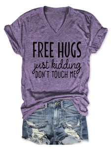 Flat lay of purple V-neck T-shirt with FREE HUGS slogan and ripped denim shorts