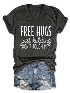 Flat lay of a grey V-neck T-shirt with Free Hugs slogan and distressed denim shorts