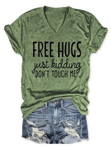 Detail of green V-neck T-shirt with Free Hugs print and distressed denim shorts