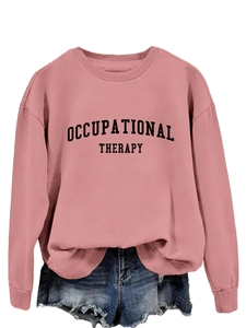 Detail eines rosa Sweatshirts mit Occupational Therapy Druck und blauen Jeansshorts