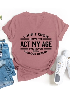 Camiseta rosa palo con cuello en V y eslogan combinada con vaqueros y zapatillas