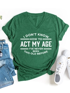 Detalle de camiseta verde con cuello en V, eslogan humorístico y textura de algodón suave