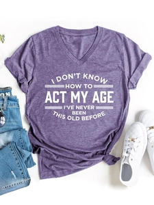 Camiseta violeta de cuello en V con cita humorística y zapatillas blancas modernas
