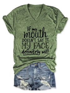 Détail d'un t-shirt vert à col en V avec slogan et short en jean bleu délavé vintage