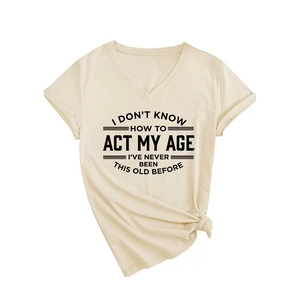 Elegante camiseta beige con cuello en V, texto gráfico negro y detalle de nudo lateral