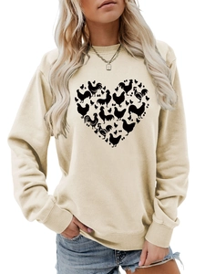 Detailed view of rib-knit crewneck and heart-shaped chicken graphic on beige sweatshirt
