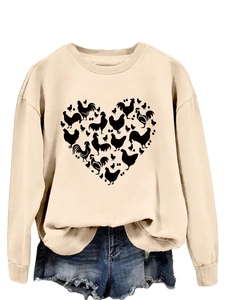 Detail of chicken heart graphic on beige crewneck sweatshirt and denim shorts