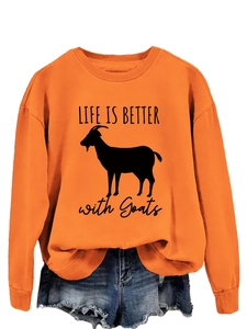 Detail of orange crewneck sweatshirt featuring Life is Better with Goats print and denim shorts