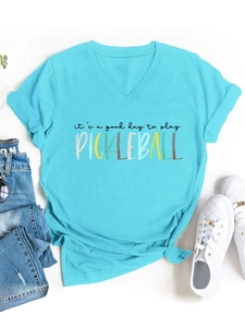 Flat lay di una t-shirt Pickleball azzurra scollo a V con sneakers e jeans