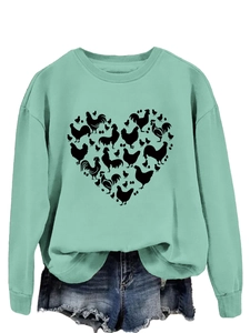Detail of mint green sweatshirt featuring a black chicken heart silhouette graphic