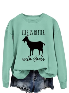 Detail of mint green crewneck sweatshirt with Life Is Better with Goats print and denim shorts