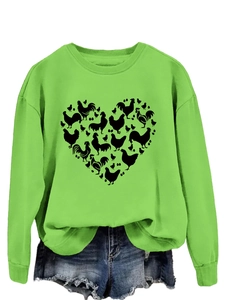 Detail of green crewneck sweatshirt showing unique heart-shaped chicken and egg pattern