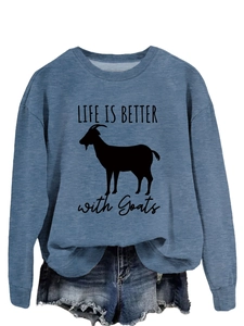 Close-up of blue crewneck sweatshirt featuring a black goat and slogan print