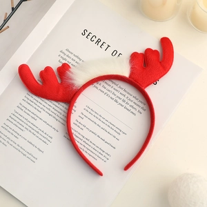 Gros plan du serre-tête rouge bois de cerf de Noël posé sur un livre ouvert