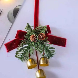 Close-up of Christmas bow with golden bells, pine cones and needles on white background