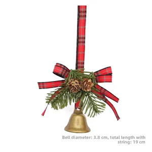 Detail of Christmas bell ornament with plaid bow, pine cones and needles on white background