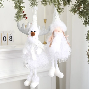 White plush Christmas angel and reindeer hanging ornaments with sequins on pine branch