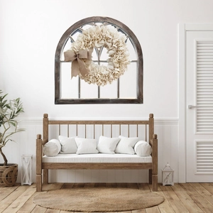 Linen wreath with burlap bow on rustic wooden window frame in farmhouse interior