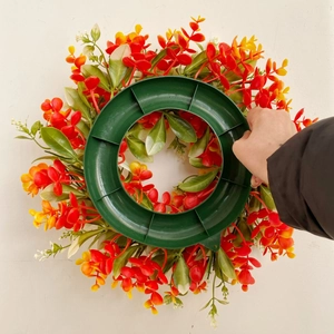 Handheld view of a colorful spring wreath with mixed artificial eucalyptus leaves and flowers