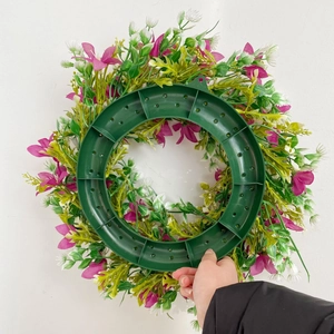 Vue arrière d'une couronne de fleurs artificielles magenta avec support de montage