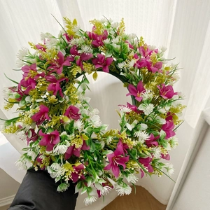 Détail d'une couronne de fleurs artificielles faites à la main en rose et blanc