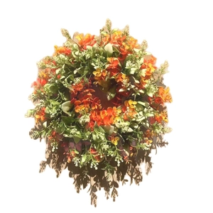 Artificial spring wreath with green eucalyptus leaves and orange flowers for home decor