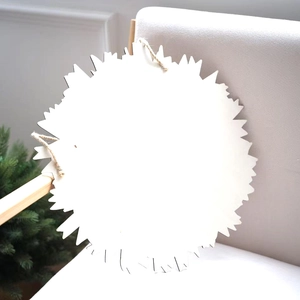 Détail d'une plaque ronde dentelée en bois blanc avec une corde de jute rustique