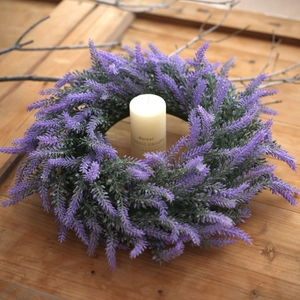 Artificial lavender wreath with purple flowers and green leaves on vintage wood backdrop