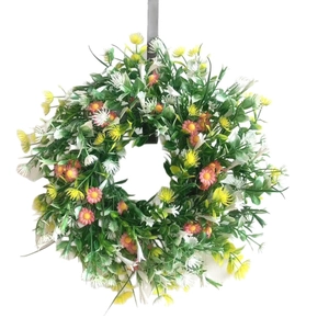 Spring artificial wreath with pink daisies, yellow wildflowers, and lush green leaves