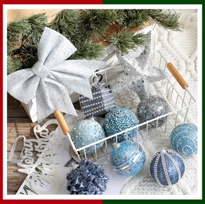 Blue glitter Christmas ornaments and silver bow arranged in a festive white basket