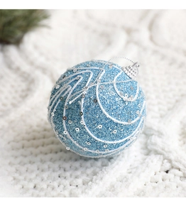 Macro detail of sky blue glitter Christmas ball with sequins on white knit background