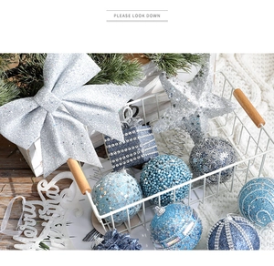 Blue and silver Christmas ornaments with glitter bows and stars in a white metal basket