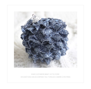 Detail of dark blue glitter Christmas ball ornament with unique pleated texture on knit fabric